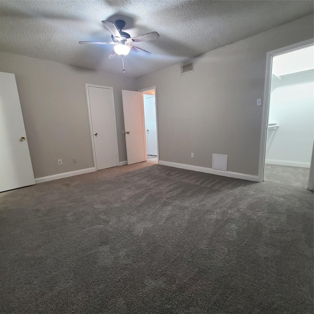 carpeted empty room with ceiling fan and a textured ceiling