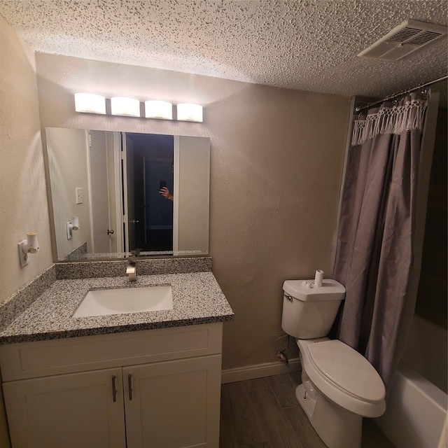 full bathroom featuring hardwood / wood-style flooring, vanity, toilet, shower / bath combo, and a textured ceiling