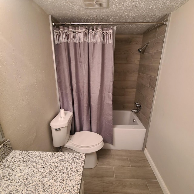 bathroom with shower / tub combo with curtain, toilet, and a textured ceiling