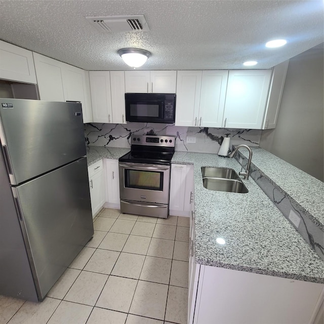 kitchen with white cabinetry, appliances with stainless steel finishes, light stone countertops, and sink