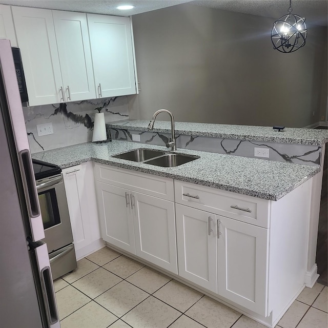 kitchen with pendant lighting, refrigerator, sink, white cabinets, and light stone counters