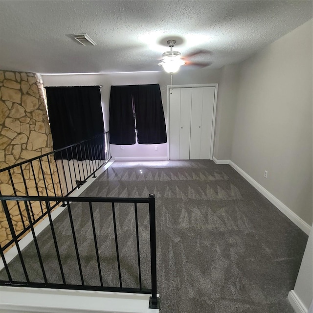 entrance foyer featuring a closet, carpet, and a textured ceiling