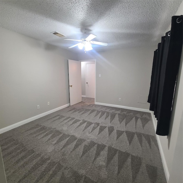 carpeted empty room with ceiling fan and a textured ceiling