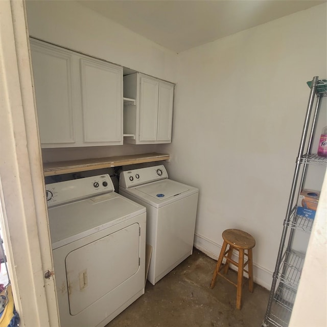 laundry room featuring washer and clothes dryer and cabinets