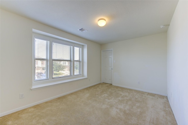 spare room featuring light colored carpet