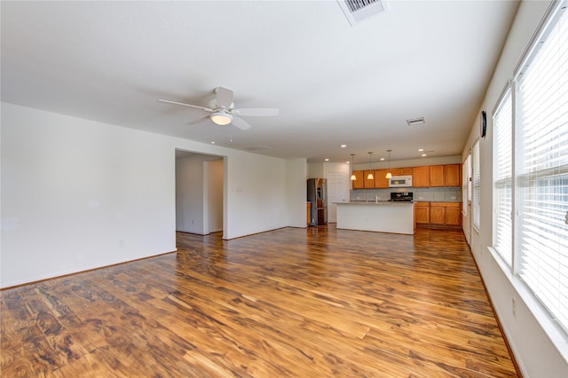 unfurnished living room with hardwood / wood-style floors and ceiling fan