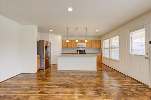 kitchen featuring an island with sink, dark hardwood / wood-style flooring, hanging light fixtures, stainless steel fridge with ice dispenser, and black range