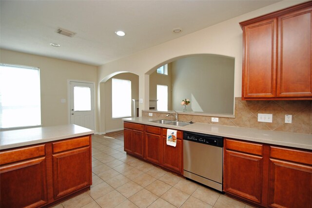 kitchen featuring tasteful backsplash, sink, stainless steel dishwasher, and light tile patterned floors