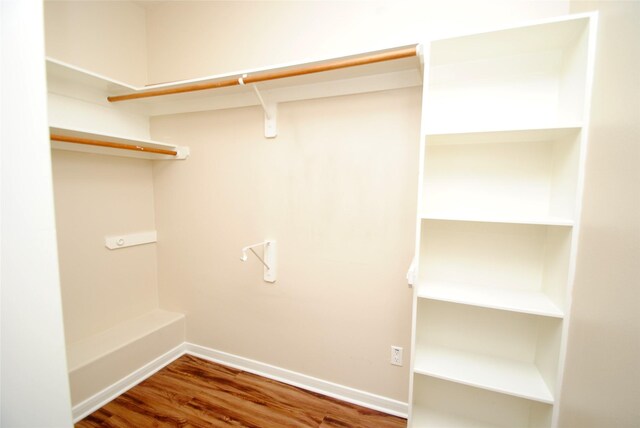 walk in closet with dark hardwood / wood-style flooring