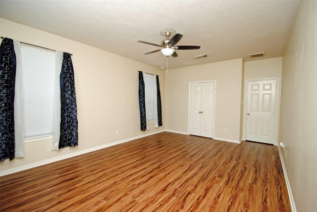 empty room featuring hardwood / wood-style floors, a textured ceiling, and ceiling fan