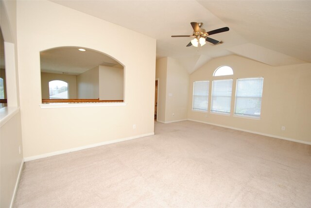 spare room with lofted ceiling, light colored carpet, and ceiling fan