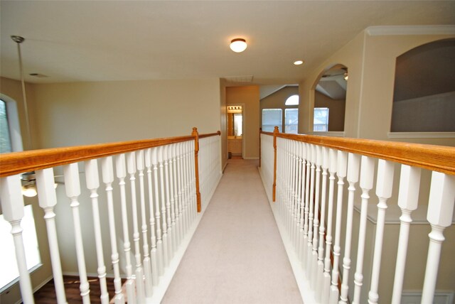 corridor featuring vaulted ceiling and light carpet