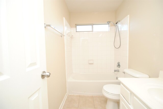 full bathroom featuring tiled shower / bath, tile patterned floors, toilet, and vanity