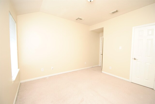 empty room with lofted ceiling and light carpet