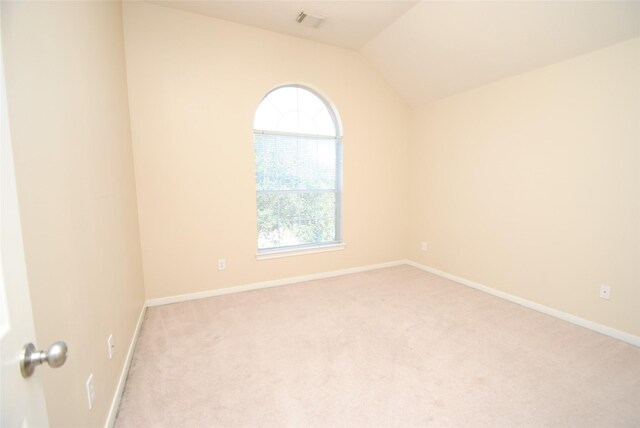 unfurnished room featuring light colored carpet and lofted ceiling