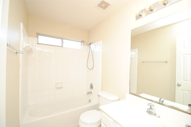 full bathroom featuring tiled shower / bath combo, vanity, and toilet