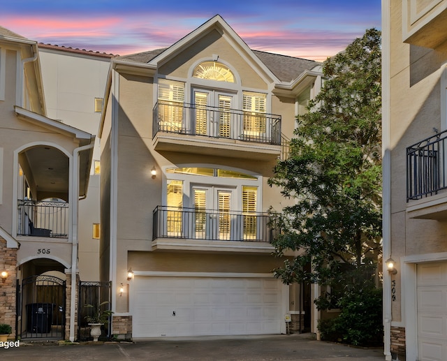 townhome / multi-family property featuring a balcony and a garage