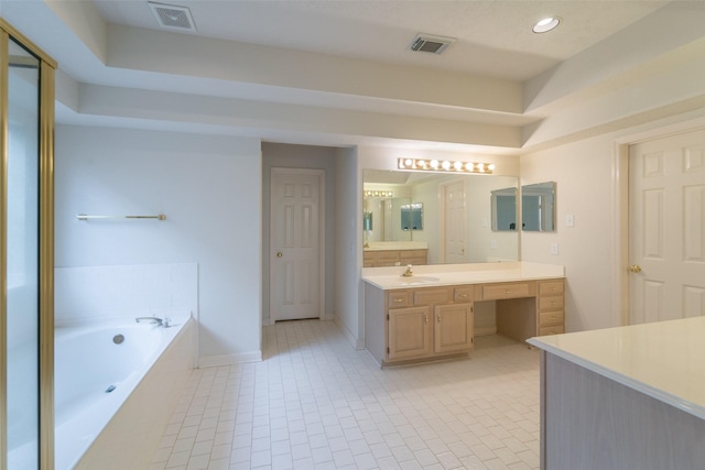 bathroom featuring a relaxing tiled tub, tile patterned floors, and vanity