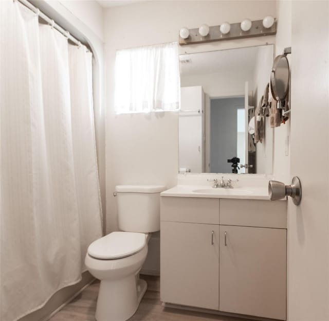 bathroom with vanity, wood-type flooring, and toilet