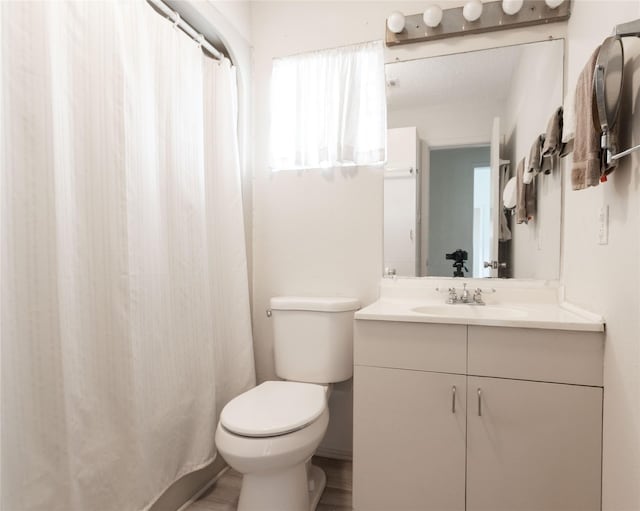 bathroom featuring vanity, wood-type flooring, and toilet