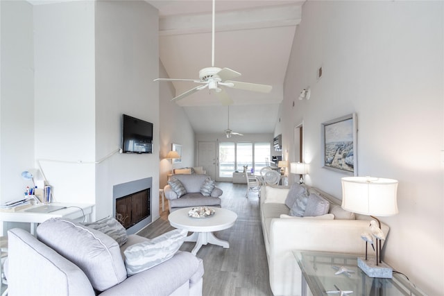 living room with hardwood / wood-style floors, high vaulted ceiling, and ceiling fan