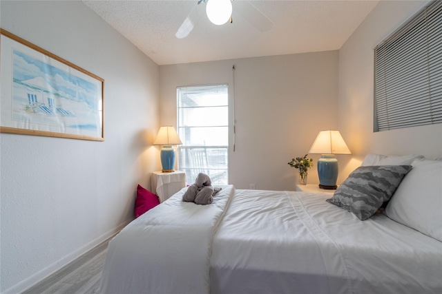 bedroom featuring hardwood / wood-style floors, a textured ceiling, and ceiling fan