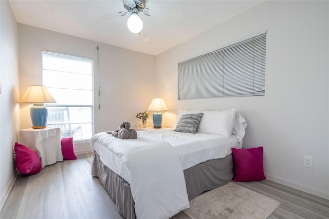 bedroom with ceiling fan, light hardwood / wood-style floors, and a textured ceiling