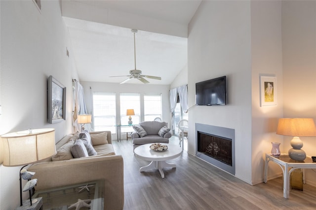 living room with ceiling fan, hardwood / wood-style floors, and high vaulted ceiling