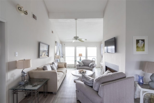 living room featuring hardwood / wood-style floors, high vaulted ceiling, beamed ceiling, and ceiling fan