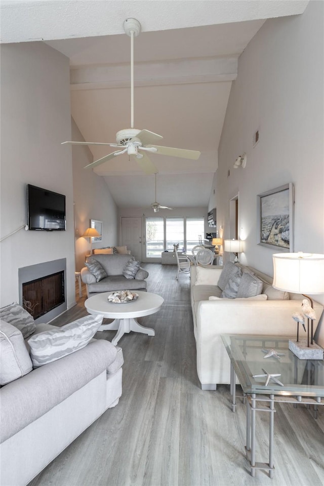 living room with hardwood / wood-style flooring, high vaulted ceiling, and beamed ceiling