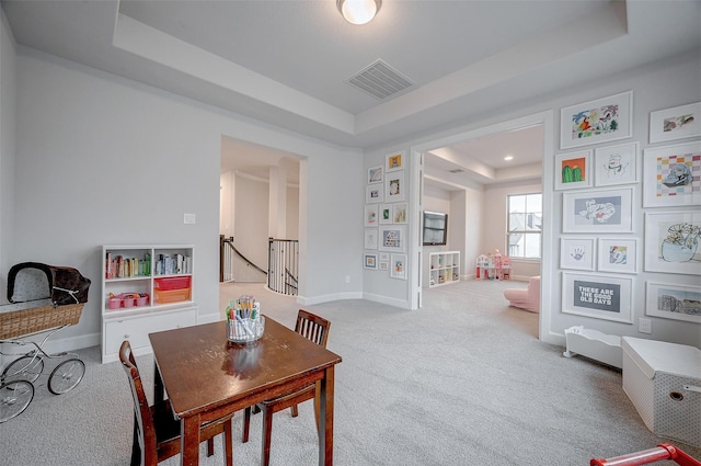 dining area featuring baseboards, visible vents, a tray ceiling, and carpet flooring