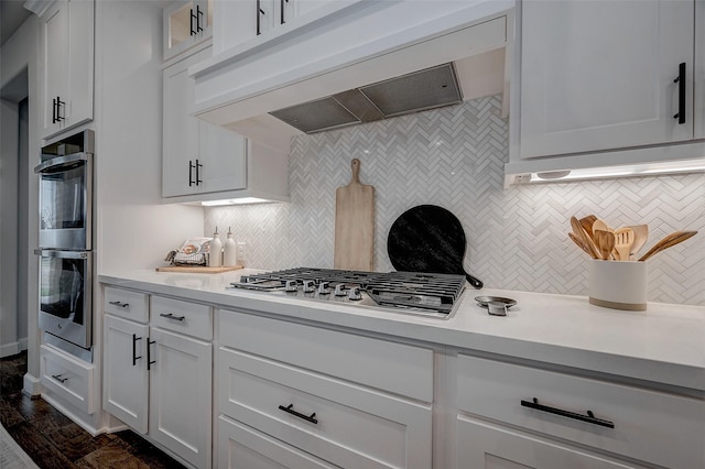 kitchen featuring white cabinets, premium range hood, light countertops, and stainless steel appliances