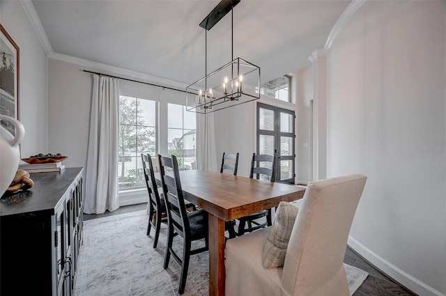 dining room featuring ornamental molding, plenty of natural light, baseboards, and an inviting chandelier