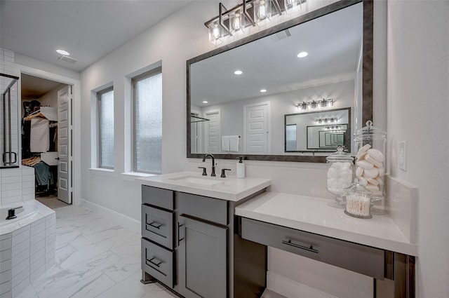 bathroom featuring marble finish floor, visible vents, a walk in closet, and vanity