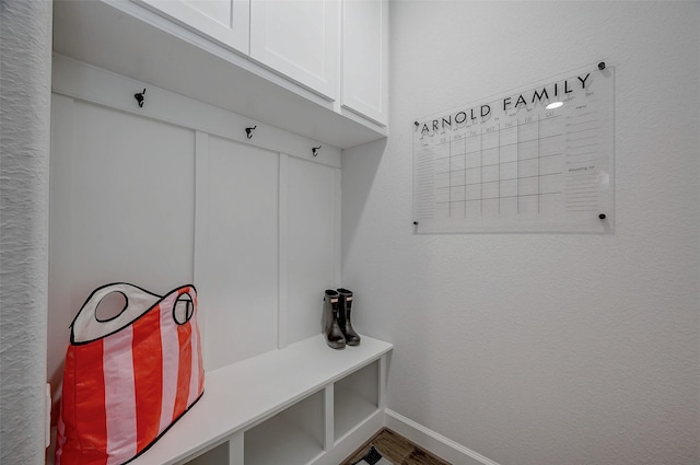 mudroom featuring a textured wall and baseboards