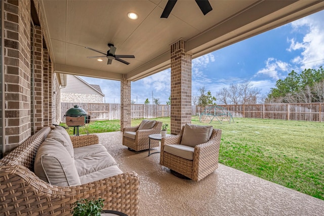 view of patio with ceiling fan, area for grilling, a fenced backyard, and an outdoor living space