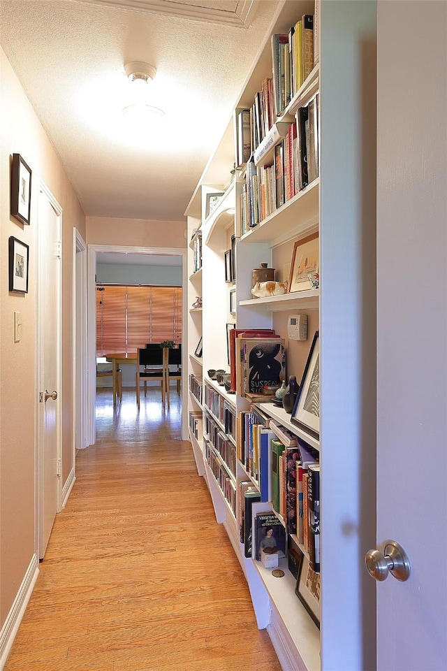 hallway with baseboards and light wood-style floors