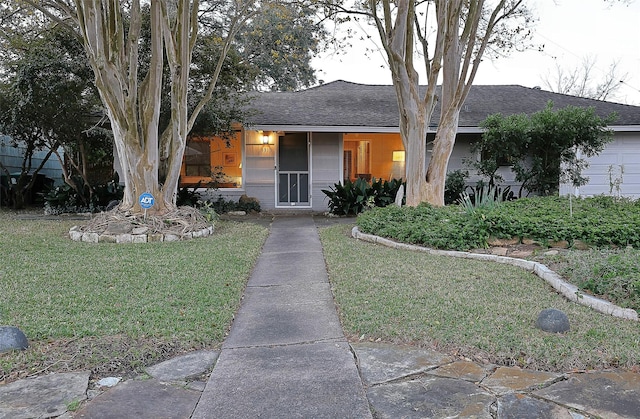 view of front of home with a shingled roof and a front lawn