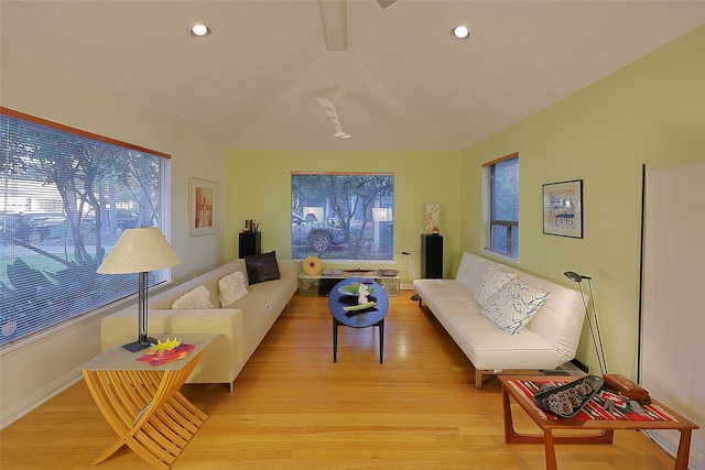 living area featuring recessed lighting, vaulted ceiling, light wood-style flooring, and baseboards