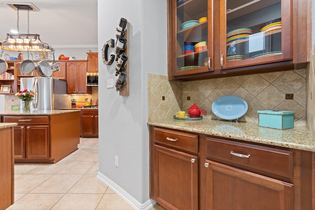 kitchen with light tile patterned flooring, glass insert cabinets, backsplash, ornamental molding, and freestanding refrigerator