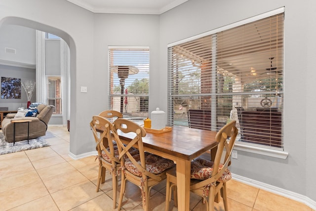 dining space featuring visible vents, ornamental molding, arched walkways, light tile patterned flooring, and baseboards