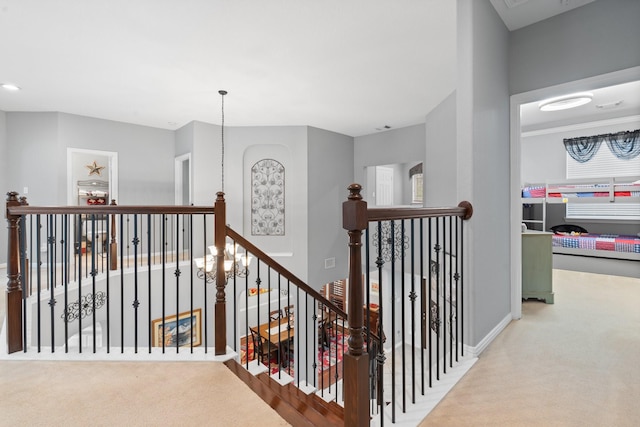 corridor with carpet flooring, baseboards, and an upstairs landing