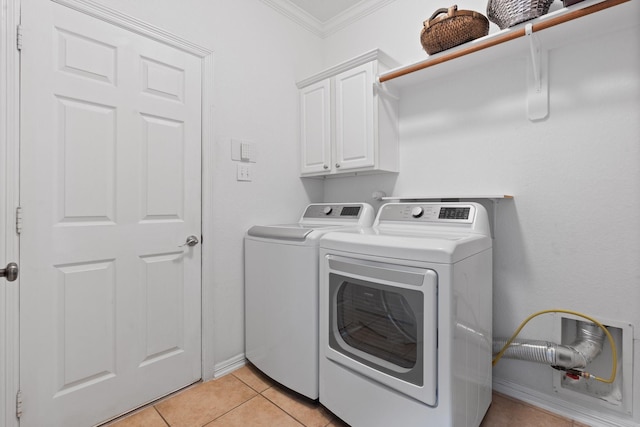 laundry area featuring light tile patterned floors, ornamental molding, washer and clothes dryer, and cabinet space