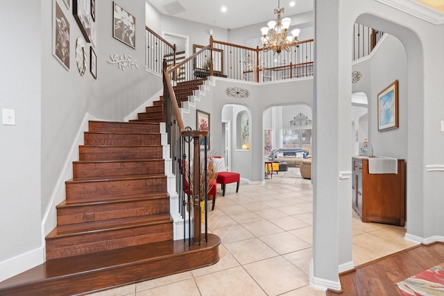 stairway with recessed lighting, visible vents, arched walkways, baseboards, and a chandelier