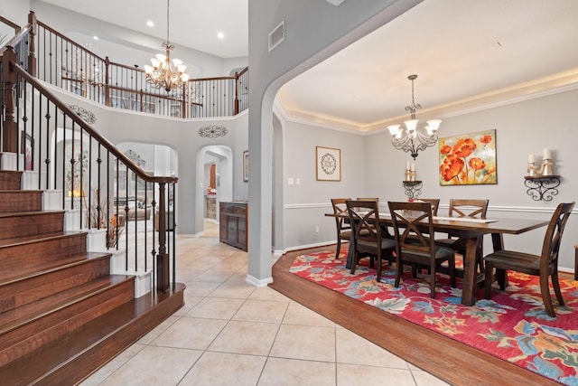 dining area featuring stairway, an inviting chandelier, visible vents, arched walkways, and light tile patterned flooring