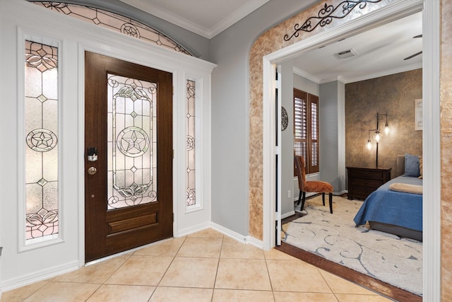 foyer featuring baseboards, visible vents, light tile patterned floors, and crown molding