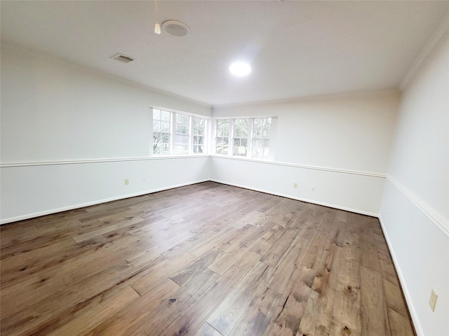 spare room featuring crown molding and hardwood / wood-style floors