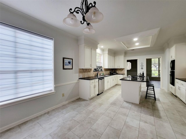 kitchen with white cabinetry, decorative light fixtures, stainless steel dishwasher, a kitchen breakfast bar, and a kitchen island