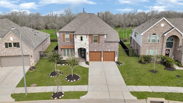 view of front of house featuring concrete driveway, an attached garage, brick siding, and a front lawn