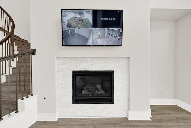 room details with a fireplace, baseboards, and wood finished floors